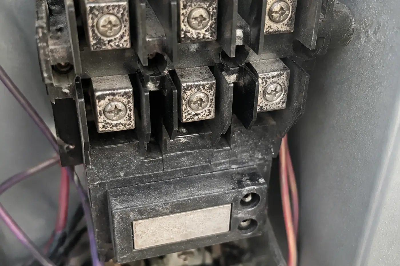 Pitted and burnt contacts on an AC contactor inside an outdoor condenser electrical panel