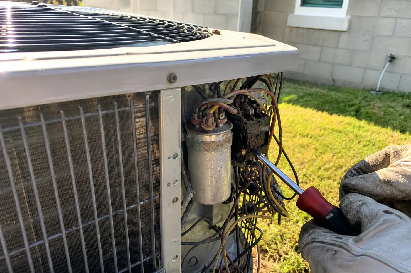 Failed run capacitor and pitted contactor inside an outdoor condenser during AC repair in Tampa