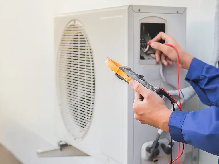 I Care Air Care technician testing the outdoor condenser during a Wesley Chapel AC tune-up