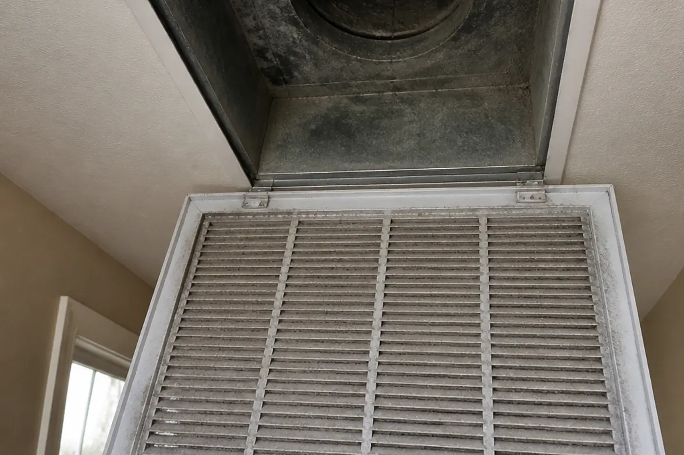Pulled ceiling register showing a dusty boot during air duct cleaning in Wesley Chapel