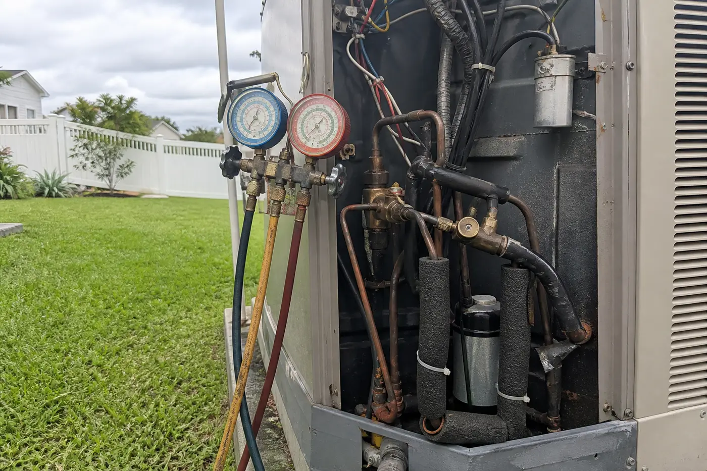 Manifold gauges on a heat pump reversing valve during heat pump repair in Tampa