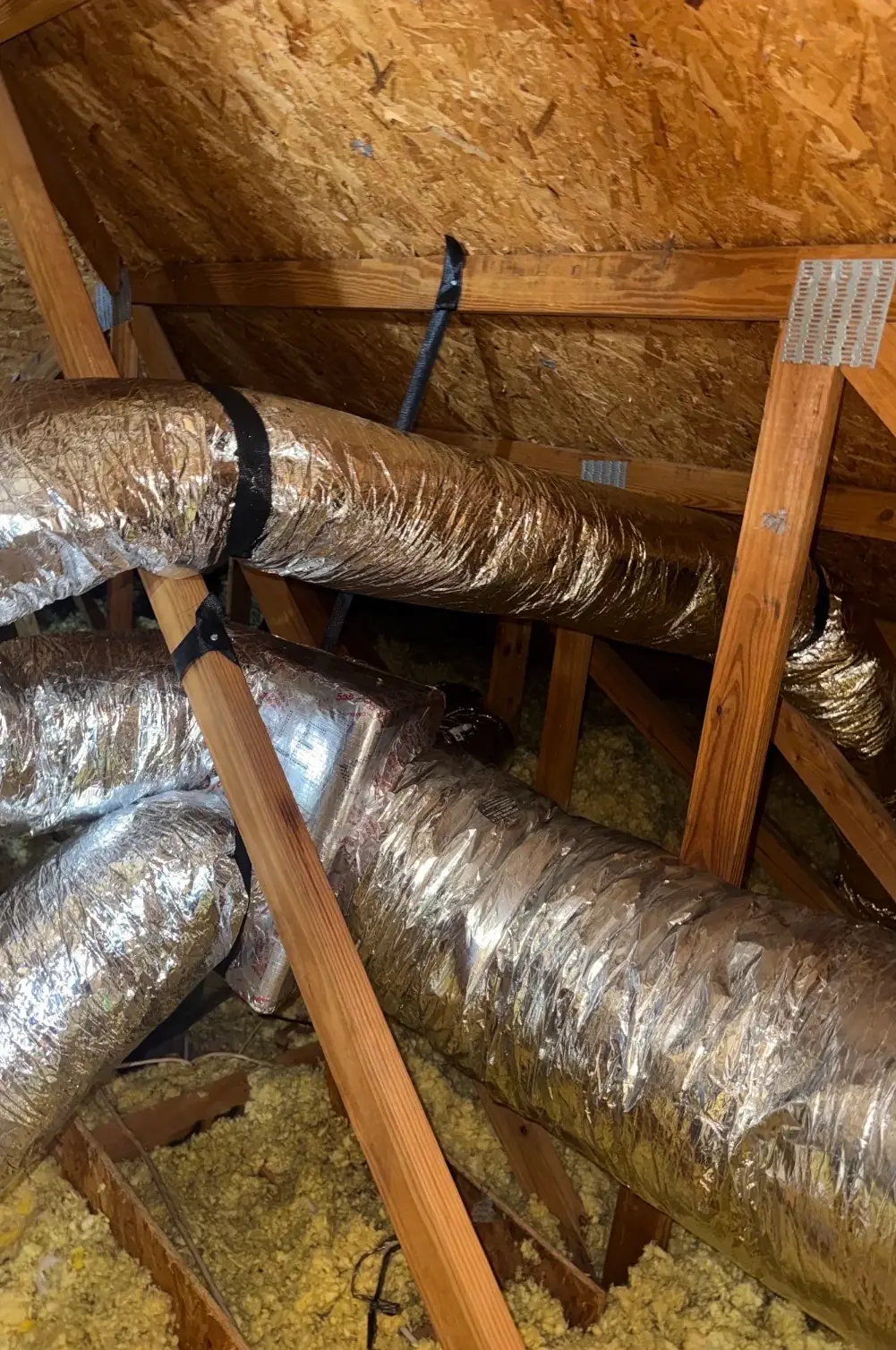Insulated supply ducts strapped in the attic on James Watkins's replacement